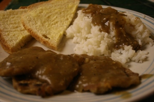 A delicious dinner of white flour and white rice covered in homemade gravy. 