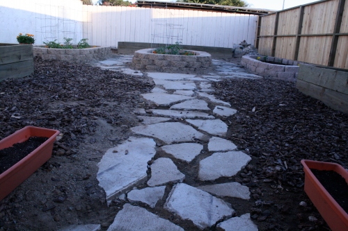 After tearing down an old decripit shed, and reusing some broken concrete to make a path around gardening beds, this piece of our backyard will soon feed us. Garden by Kerri. Photo by Christopher.